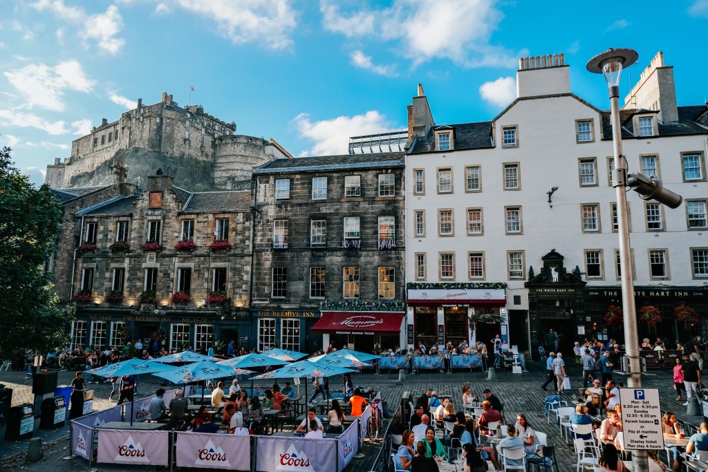 Near Victoria Street where people are eating outside with Edinburgh Castle in the Background