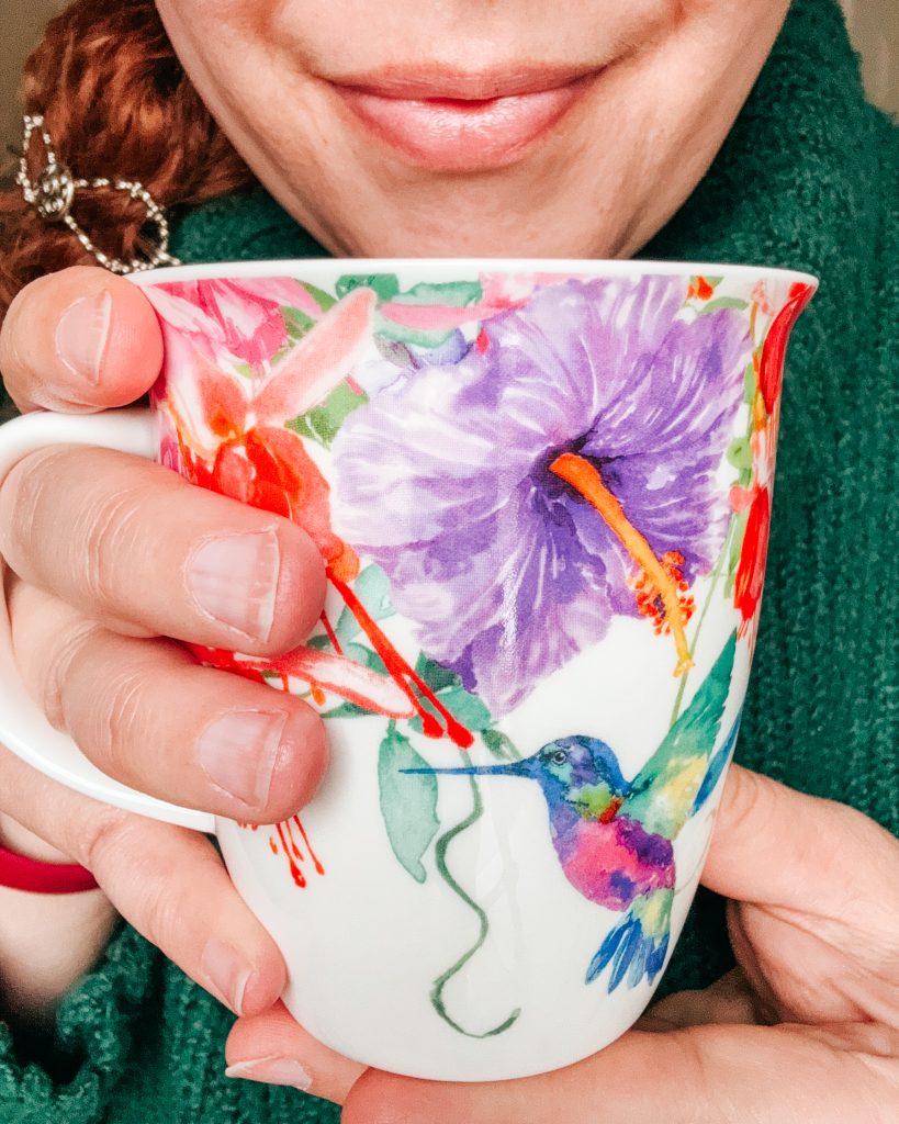Author smiling with a mug of tea