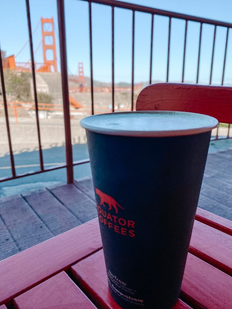 A matcha latte outside of Equator Coffee with the Golden Gate Bridge in the background in San Francisco