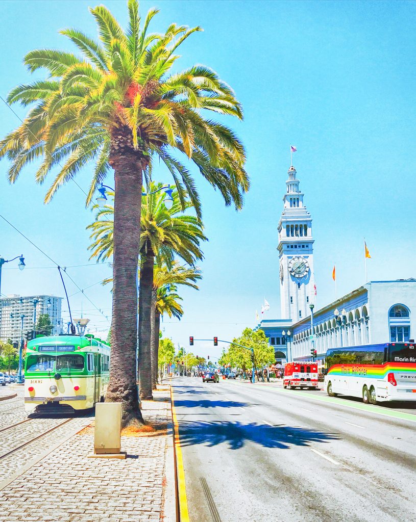 Ferry building and three trolley with palm trees
