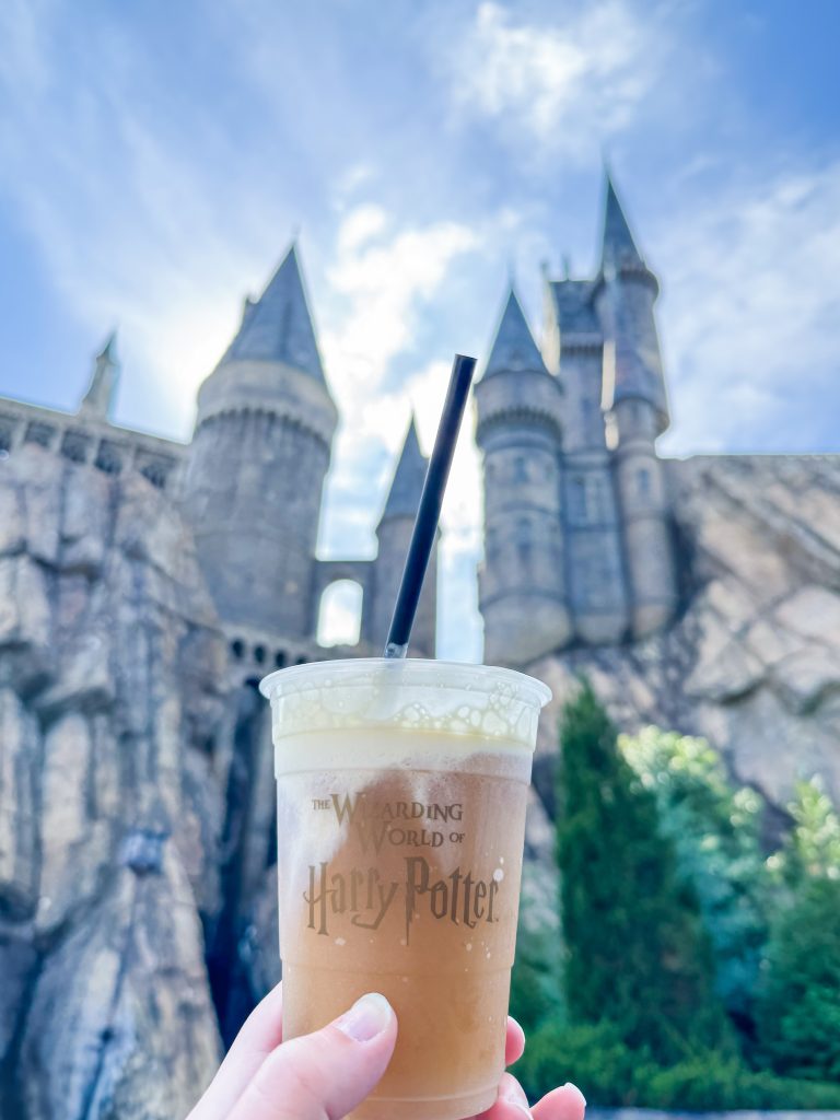 Frozen Butterbeer with Hogwarts in the background at Universal Orlando